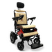 The ComfyGo MAJESTIC IQ-9000 Auto Folding Electric Wheelchair features a beige quilted cushion, a sleek black lightweight aluminum frame for easy maneuverability, an adjustable headrest, digital joystick controller, large rear wheels with smaller front wheels, armrests, and an elevated footrest for added comfort.