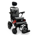 The ComfyGo MAJESTIC IQ-9000 Auto Folding Electric Wheelchair has a lightweight aluminum frame, padded gray cushions, and adjustable armrests with a headrest. It features a black and red design with a digital joystick on the right armrest and front wheels for enhanced mobility.