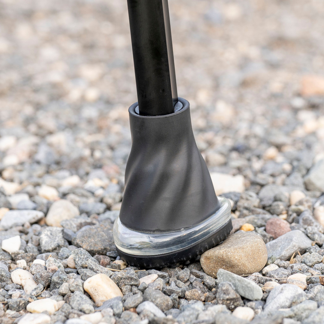 Close-up of a black rubber cane tip on gravel, surrounded by small stones—designed for use with Drive Air-Crutches featuring Airgonomic™ Underarm Cushions.