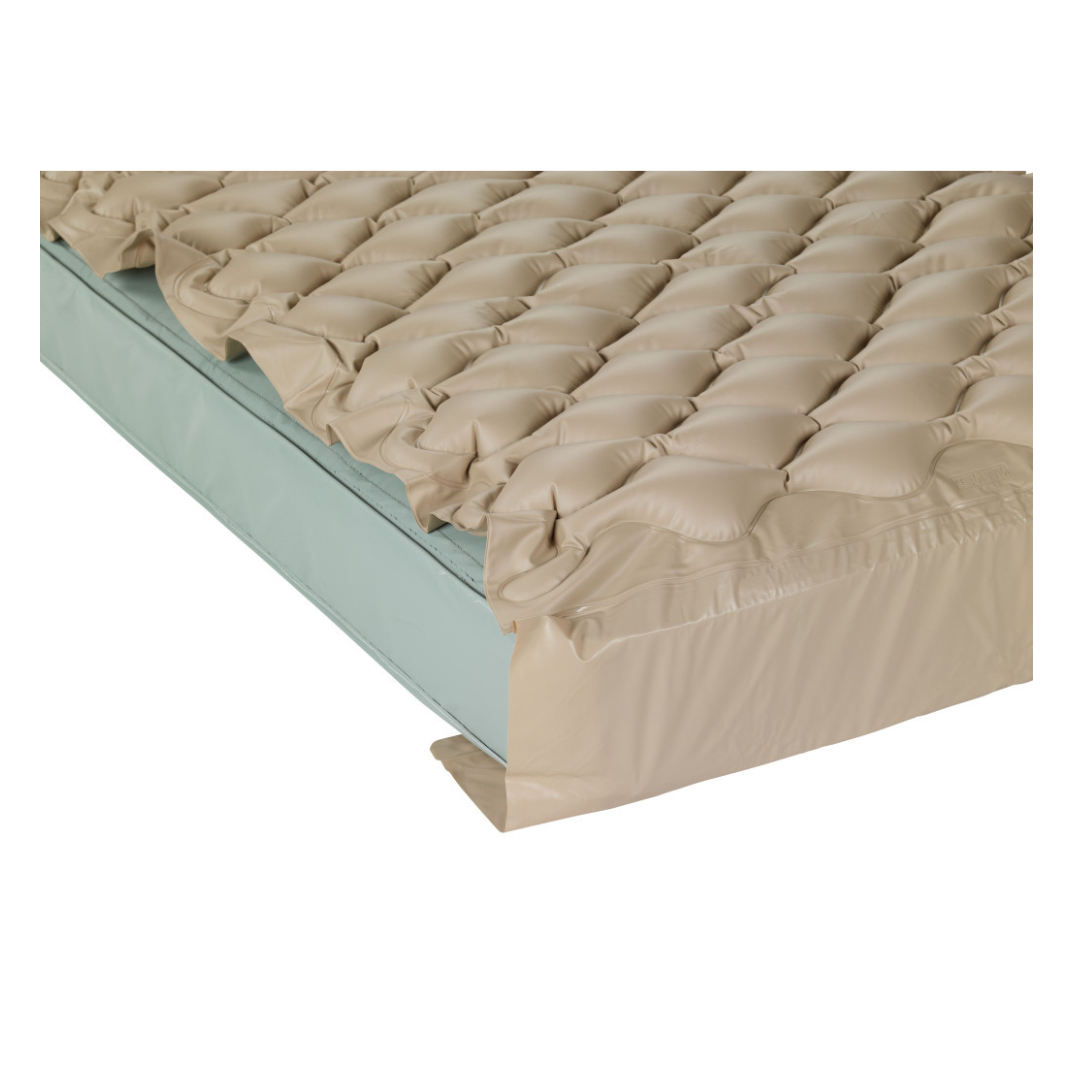 A Drive Med-Aire Alternating Pressure Pump and Pad System with a beige bubble-patterned inflatable pad is placed atop a light blue standard mattress.