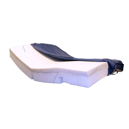 A Med-Mizer Active Care Elite Copper Infused Mattress with an angular, contoured shape is partially covered by a fitted dark blue cover, which is pulled back to reveal the copper-infused memory foam beneath.