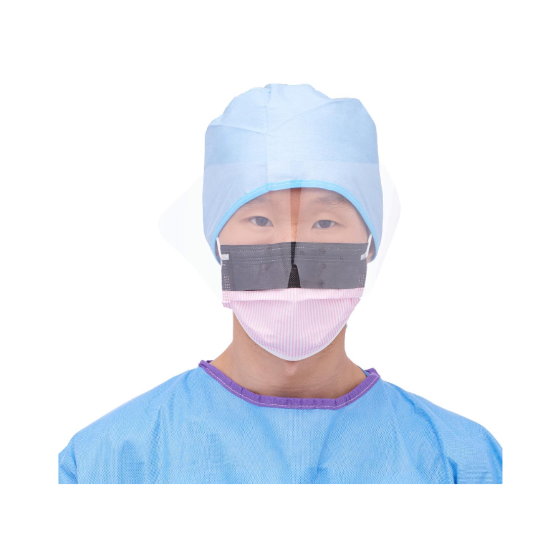 A person in a blue surgical cap and gown wears a Medline ASTM L3 Procedure Face Mask with Eye Shield and Ear Loops, featuring a black rectangular strip, facing forward against a white background.