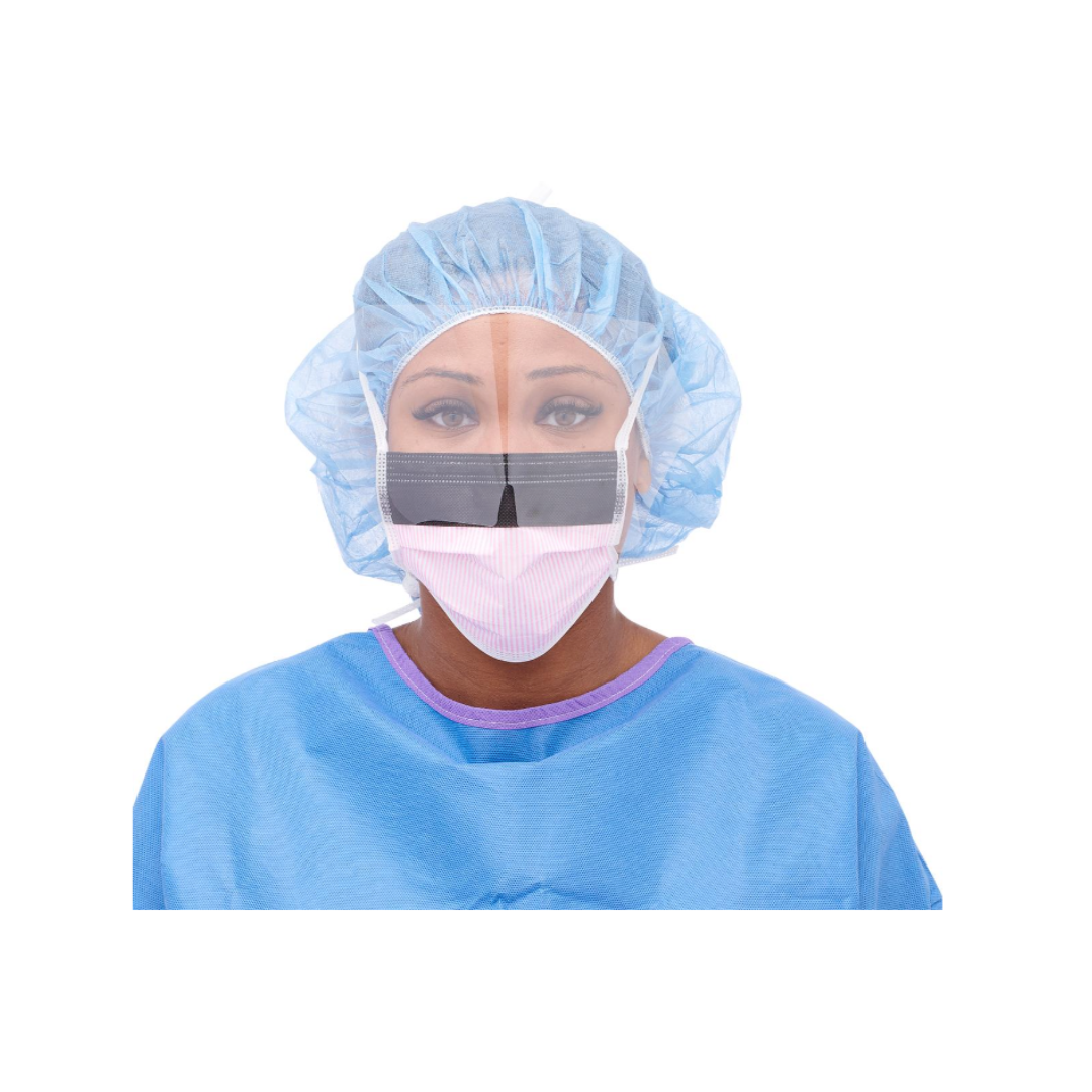 A person wears a blue surgical gown, hair cover, and a Medline ASTM Level 3 Surgical Face Mask with Eye Shield, aiding communication. The background is white.