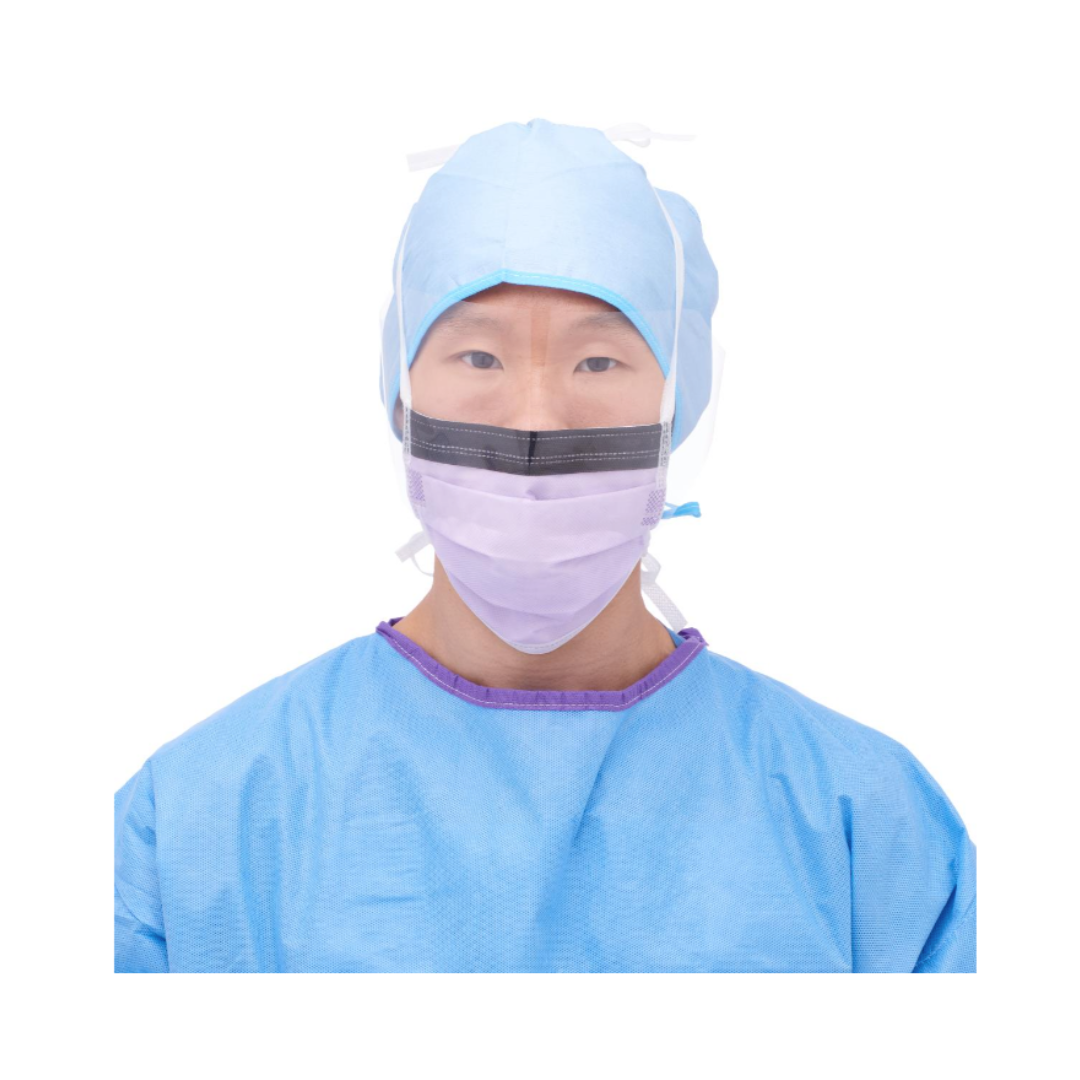 A medical professional facing forward wears a blue surgical cap, a blue surgical gown, and a Medline ASTM Level 3 Surgical Face Mask with Eye Shield against a white background.
