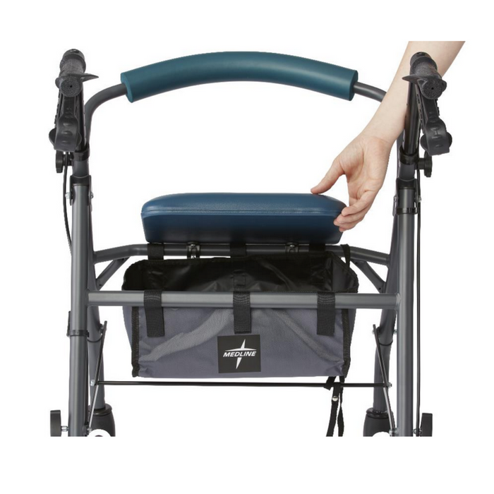 A hand lifts the gray seat of a Medline Steel Rollator with a blue cushion, featuring handlebars and brakes for stable mobility. It includes a storage compartment labeled Medline for added convenience.