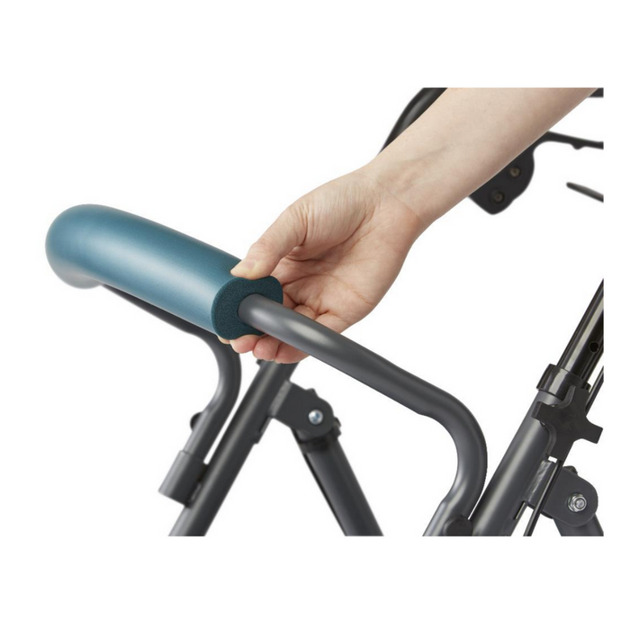 A hand grips the foam-covered handle of a Medline Steel Rollator with Microban, showcasing its metallic gray frame with teal comfort padding. This image emphasizes the blend of practicality and design in this assistive equipment.