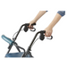 With both hands gripping the handles of a Medline Steel Rollator with Microban, a person in a denim jacket focuses intently. The image highlights the blue rollators upper section, showcasing its padded seat and sturdy frame.
