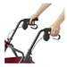 Hands adjusting the handles of a red Medline Steel Rollator with Microban, featuring brakes and curved grips. The metallic frame is partially visible, showcasing the antimicrobial handlebar mechanism for improved safety and hygiene.