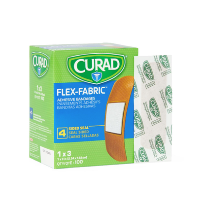 A green box of Medline CURAD Flex-Fabric Adhesive Bandages - 1" x 3" Strips is shown with one bandage and its wrapper beside it; the box includes 100 bandages with four-sided seal protection.