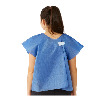 A woman with a ponytail is seen from behind wearing a Medline Disposable Multilayer Patient Cape, 30" x 21", blue, with a white velcro fastener at the upper back and short sleeves for added comfort.