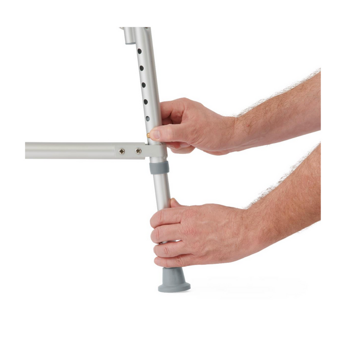 Two hands adjust the Medline Bariatric Shower Chair with Back, made from heavy-duty aluminum. One hand stabilizes the structure while the other sets the leg height using precision holes. The leg features a gray rubber tip for enhanced stability.