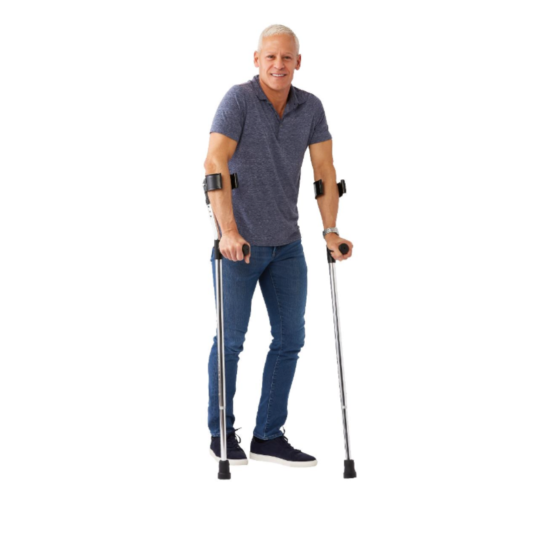 A smiling man with short gray hair uses Medline Premium Forearm Crutches, dressed in a blue polo shirt, jeans, and dark sneakers, standing against a plain white background.