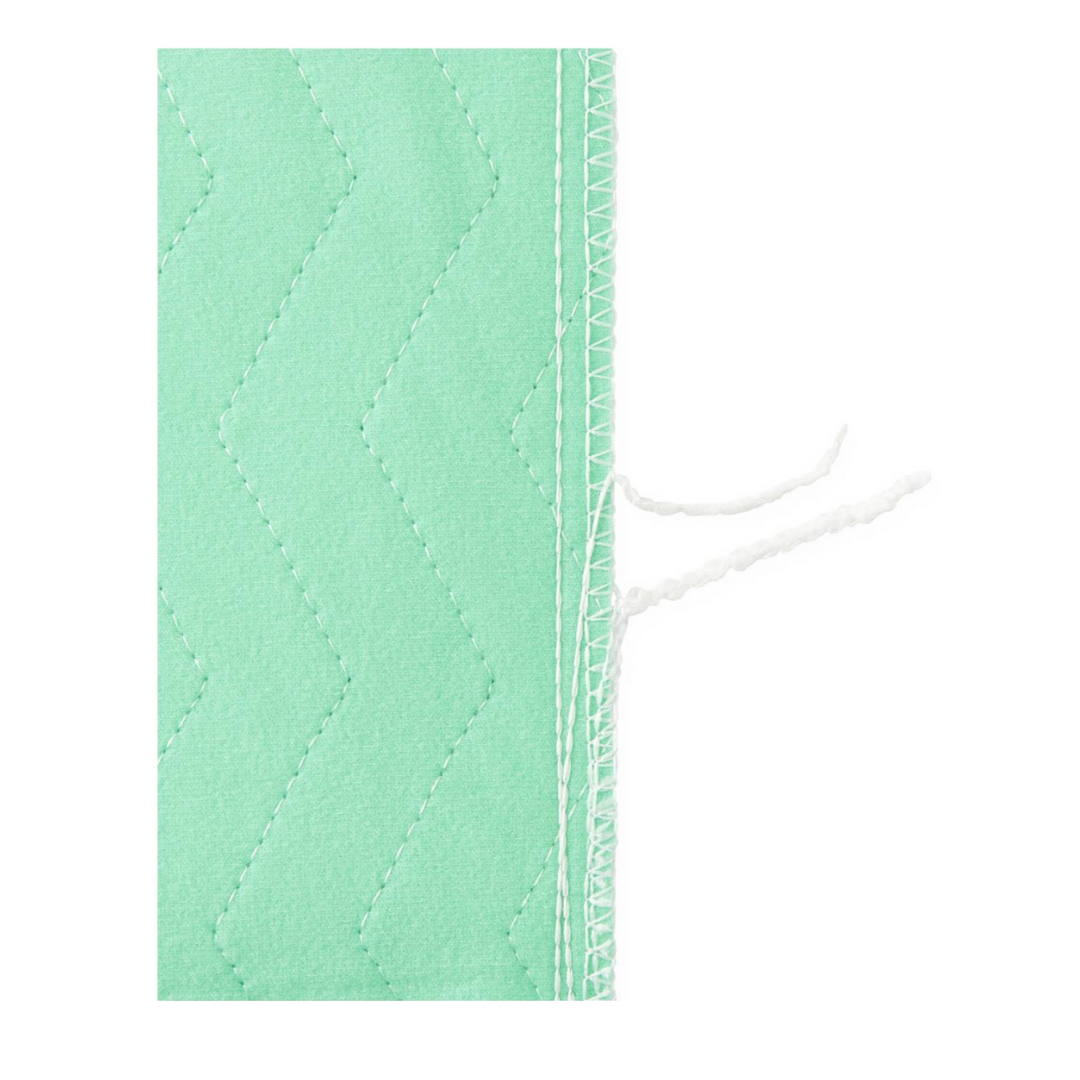 Close-up of Medline Quick Dry Poly Laminated Reusable Underpads (34 x 36) showing light green quick-dry fabric, zigzag stitching, and two loose white threads near the edge to highlight seam detail and texture.