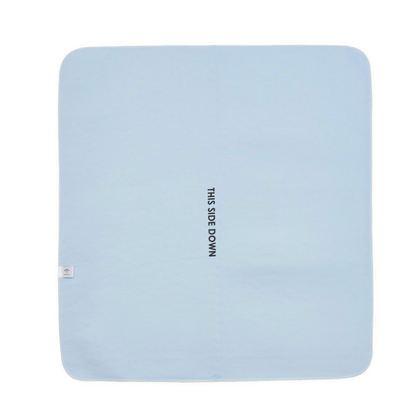 The Medline Quick Dry Poly Laminated Reusable Underpad, 34 x 36, is light blue, rectangular, with THIS SIDE DOWN in black at the center and a small white tag near one corner. Made from an advanced fiber blend.