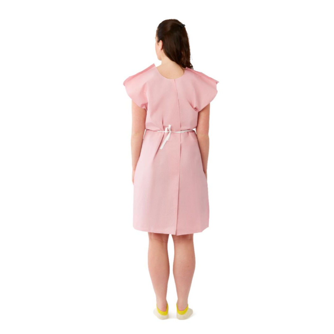 A person faces away, wearing a pink Medline Reinforced Tissue Patient Gown tied at the waist with a white belt and yellow slippers, against a plain white background.
