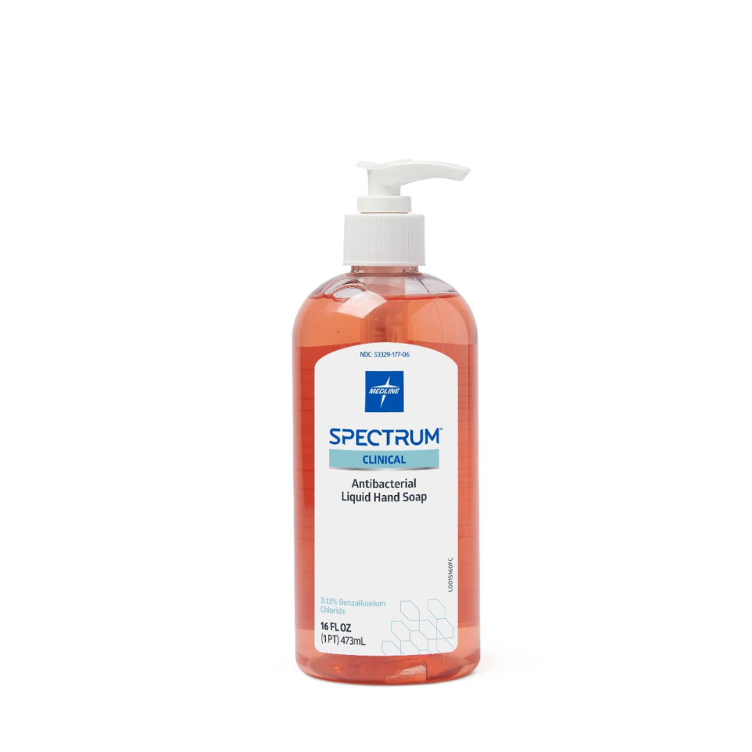 A clear pump bottle of Medline Spectrum Antibacterial Liquid Hand Soap, filled with vibrant orange soap and featuring a white label, stands upright against a plain white background.