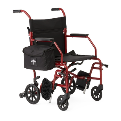The Medline Steel Transport Chair with Wide 19" Seat features black upholstery, foldable footrests, padded armrests, and a side storage bag, providing a reliable and lightweight mobility aid for easy transport.