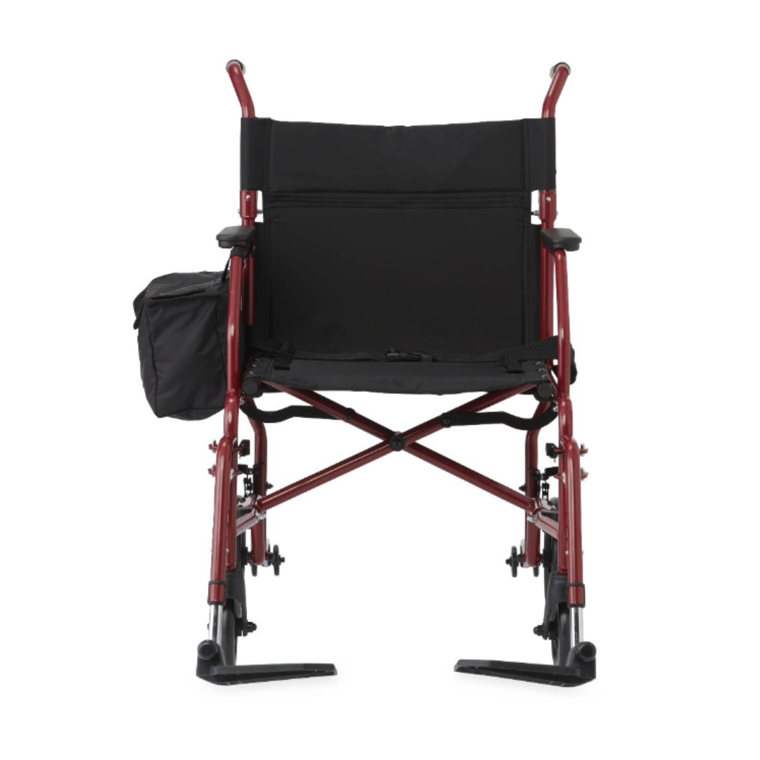 The Medline Steel Transport Chair with Wide 19" Seat is shown from the back in red, featuring black seat fabric, rear handles, leg rests, and a side storage pouch attached to one armrest for practical mobility and convenience.
