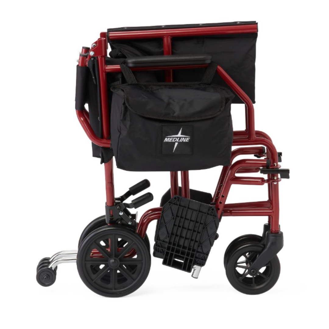 A red Medline Steel Transport Chair with Wide 19" Seat is shown folded with a black storage bag, black wheels, and visible footrests.