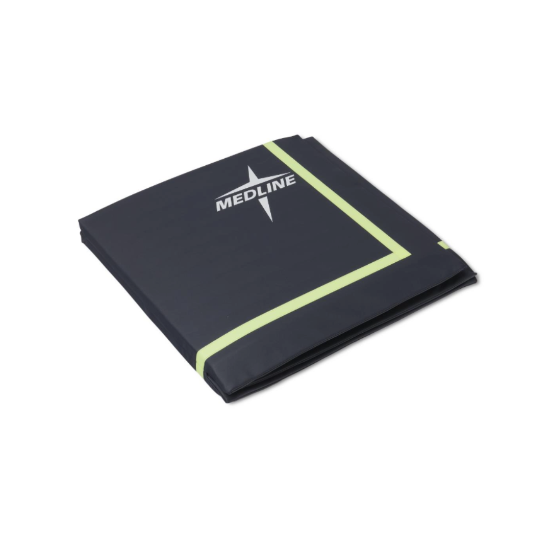 A folded, dark-colored Medline Trifold Beveled Edge Fall Mat with Glow features light green trim and a MEDLINE star logo on the surface, displayed against a white background.