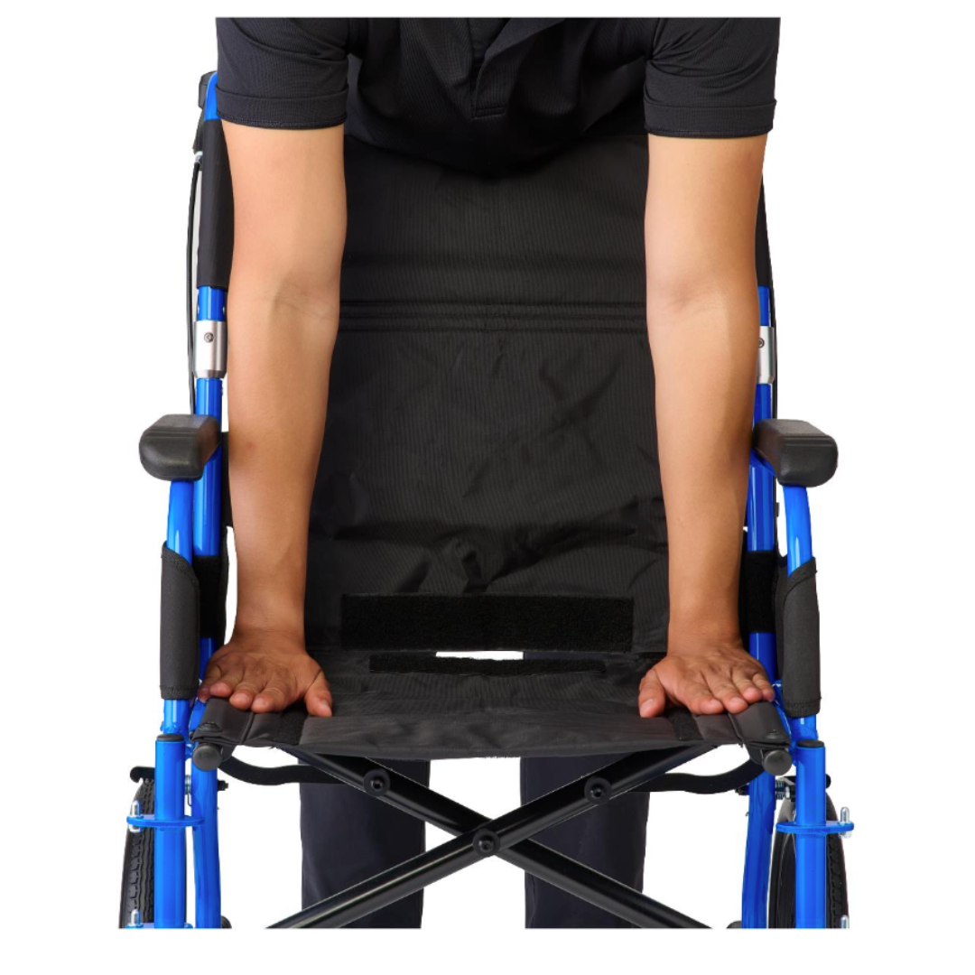 A person stands behind a Medline Zero G Ultralite Transport Chair with a blue seat and aluminum frame, pressing down on the seat with both hands, possibly to fold or adjust the lightweight chair.