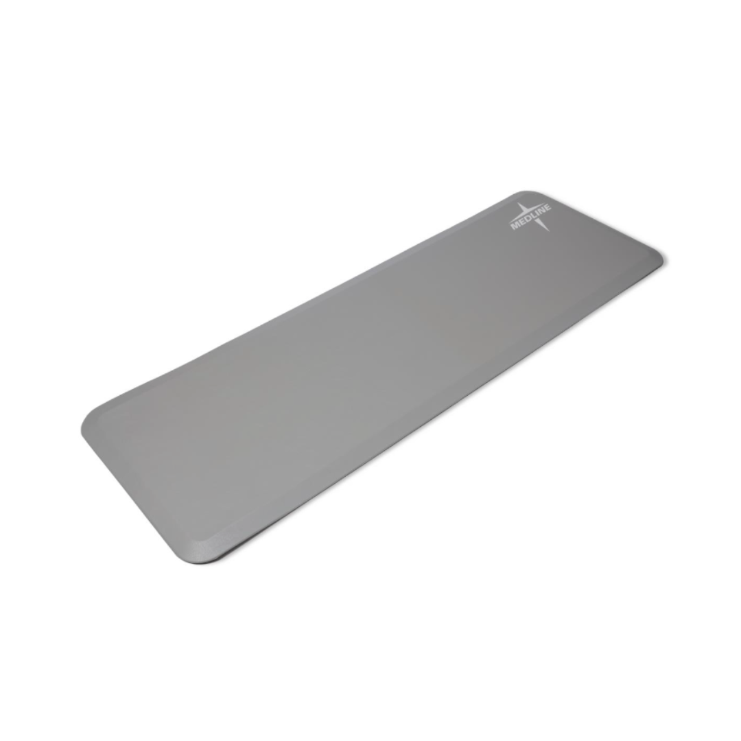 The Medline Beveled Edge Bedside Fall Mat is a rectangular, light gray mat with rounded corners and a small white logo, ideal for home gyms. Check the spec table for a detailed description and full specifications.