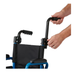 A person’s hands are attaching a black adjustable push handle to the frame of a blue and black Medline Pediatric Kidz Guardian Wheelchair, set against a plain white background.