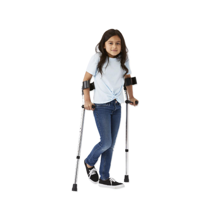 A young girl with long dark hair, in a light blue shirt, jeans, and black sneakers, stands with Medline Premium Forearm Crutches against a plain white background.