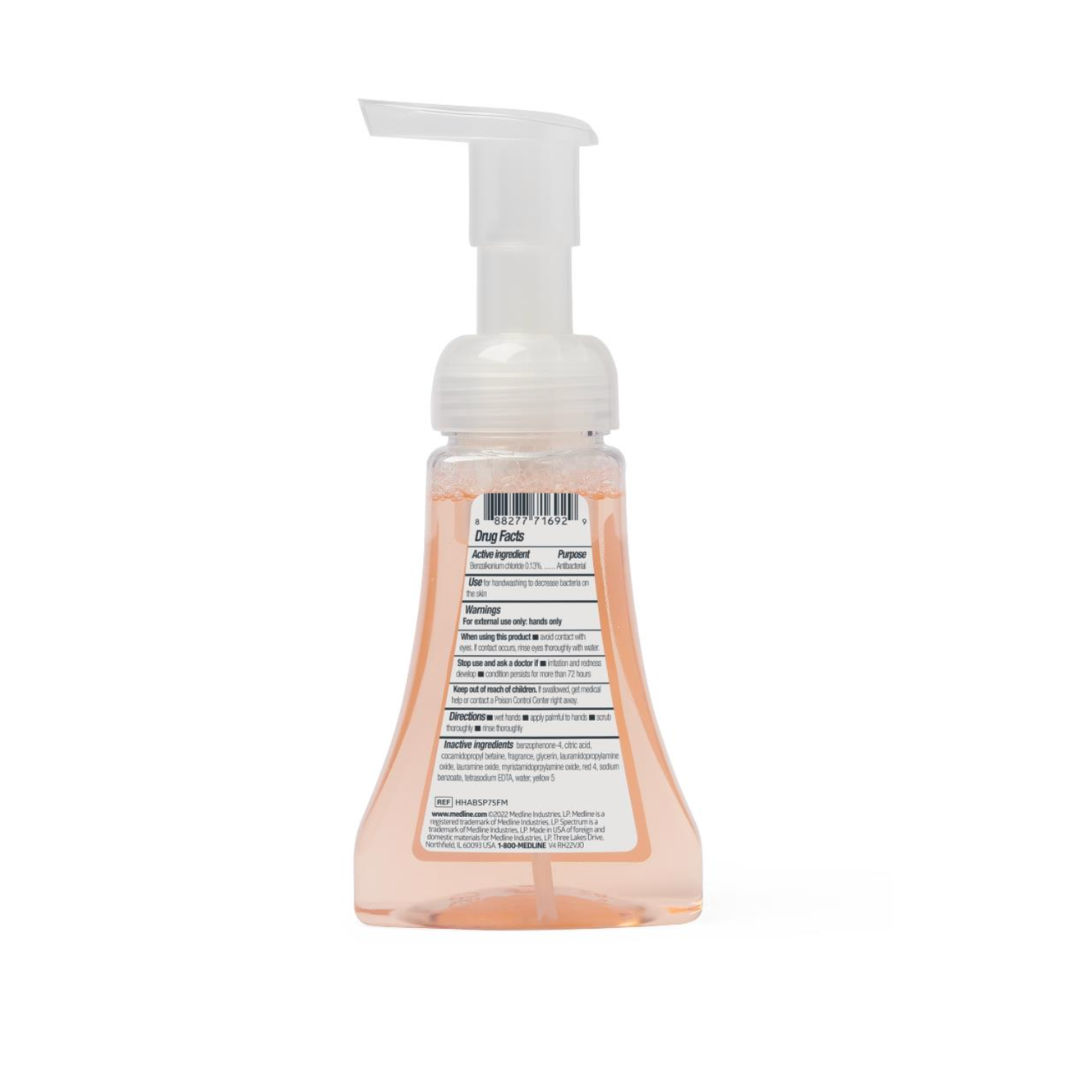 A clear pump bottle of Medline Spectrum Antibacterial Foaming Hand Soap, peach-colored liquid visible from the back, with a white label containing product details and a white foaming pump top for effective germ protection.