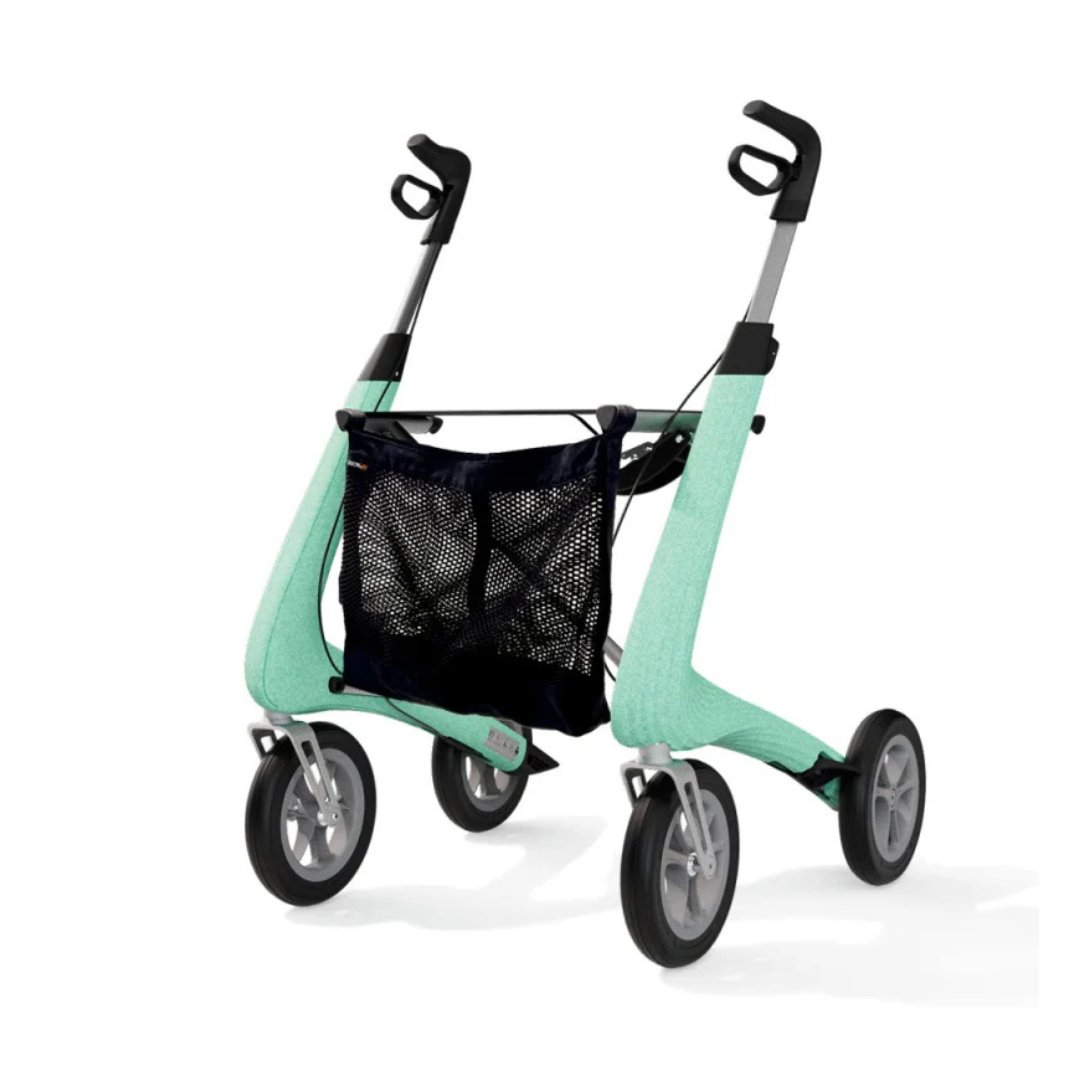 Featuring the Mesh Bag For ByAcre Rollators, this modern, mint green four-wheeled walker is equipped with black handles and showcases the spacious mesh bag as a convenient accessory, all set against a white background.