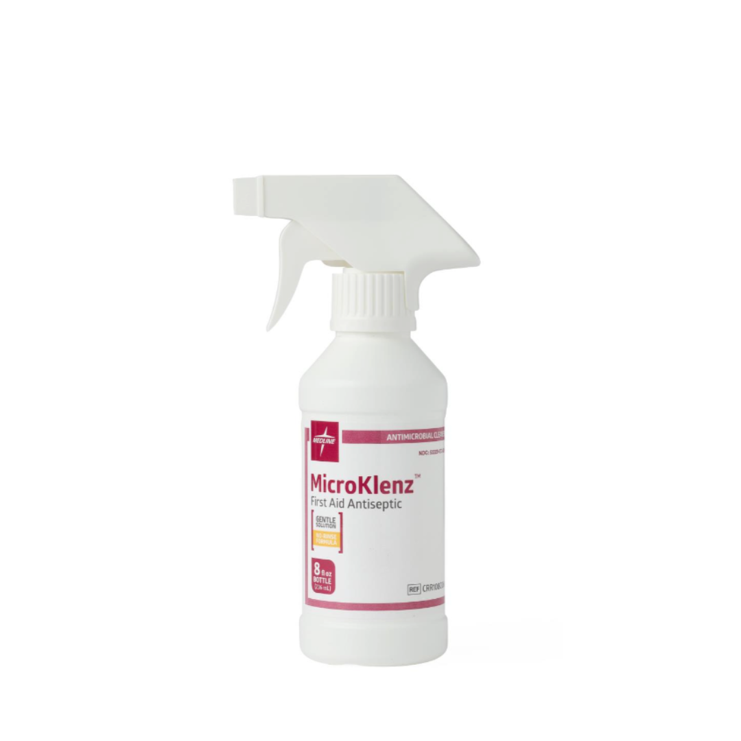 A white spray bottle of Medline MicroKlenz Antimicrobial First Aid Antiseptic, 8 fl oz, featuring a white and pink label with a cross symbol, is displayed against a white background.
