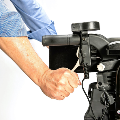 A person in a blue shirt holds the handle and hand brake of the Miracle Mobility Portable 4N1 Walker Wheelchair Combo, shown against a white background.
