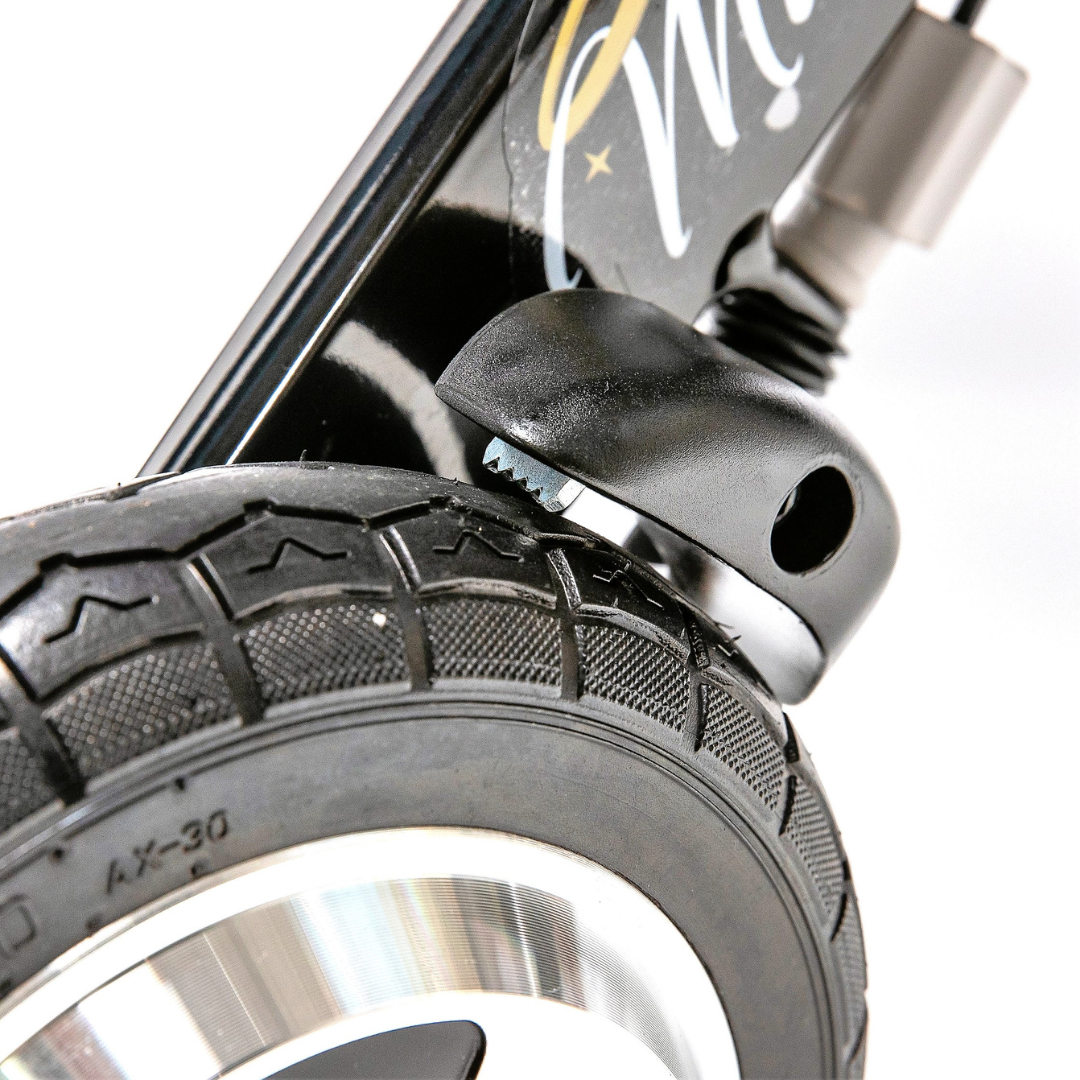Close-up of a black wheel attached to the frame of the Miracle Mobility Portable 4N1 Walker Wheelchair Combo, highlighting the tread and suspension; its decorated deck features elegant cursive writing for a stylish, smooth mobility experience.