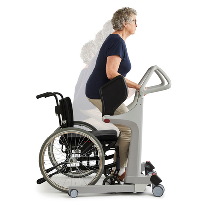 An older woman uses the Molift Transfer Pro – Innovative Sit-To-Stand Patient Lift to rise from her wheelchair. The device supports her as she transitions from sitting to standing, emphasizing mobility assistance.
