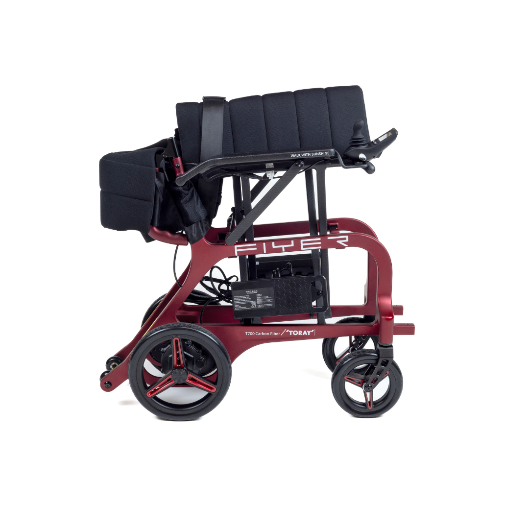 The Monarch Flyer Ultra-Lite Carbon Powerchair is a modern, foldable red wheelchair with a black seat and large rear wheels, shown fully folded for easy transport or storage. See specifications or videos to learn more.