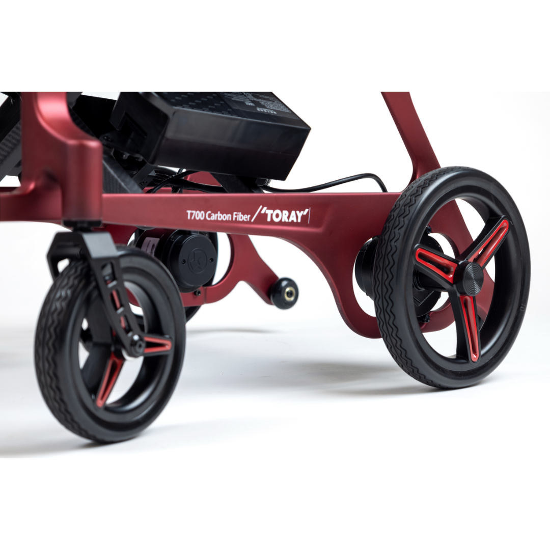 Close-up of the Monarch Flyer Ultra-Lite Carbon Powerchair, featuring black and red wheels, a sleek red carbon fiber frame, and "T700 Carbon Fiber / TORAY" printed on the side. See specifications for details.
