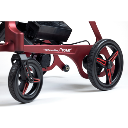 Close-up of the Monarch Flyer Ultra-Lite Carbon Powerchair, featuring black and red wheels, a sleek red carbon fiber frame, and "T700 Carbon Fiber / TORAY" printed on the side. See specifications for details.