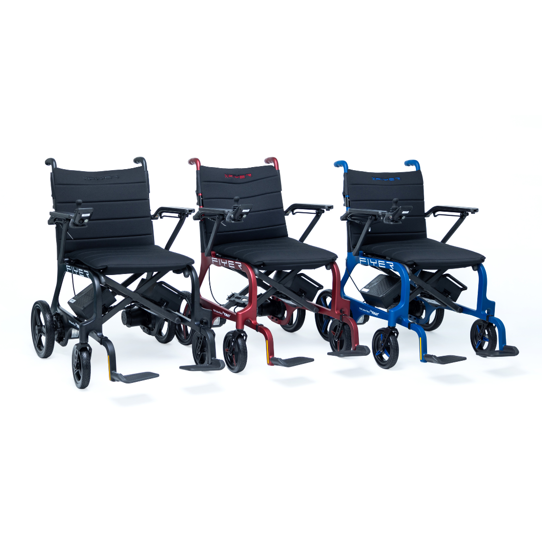 Three Monarch Flyer Ultra-Lite Carbon Powerchairs in black, red, and blue are shown in a row. Each chair is foldable, lightweight, and has padded seats, armrests, footrests, and small wheels. See specs for mobility features.