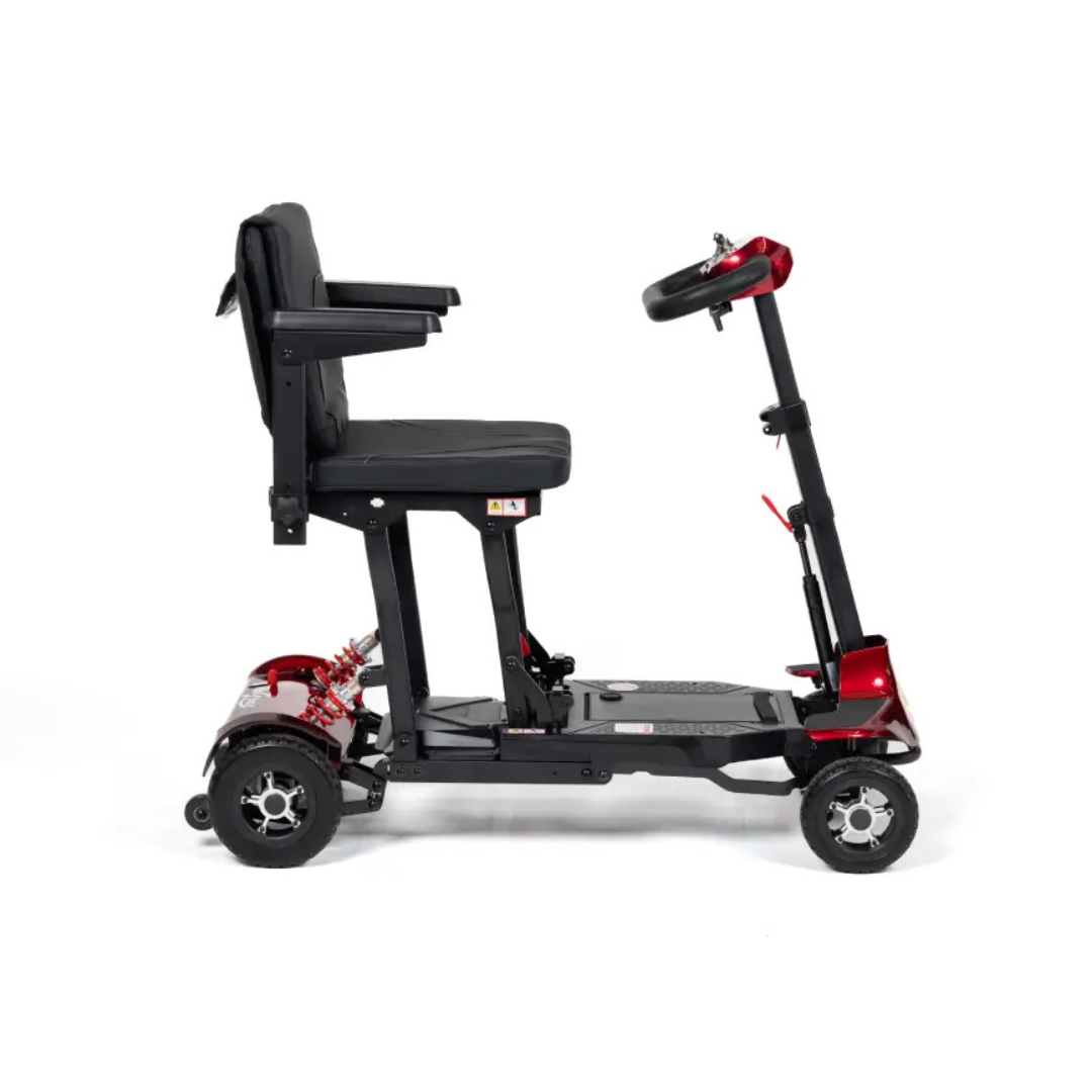 A side view of the Monarch Genie Lightweight Portable Scooter, a compact four-wheeled mobility scooter featuring a black seat, armrests, and red accents on the frame, designed for personal transportation and enhanced accessibility.