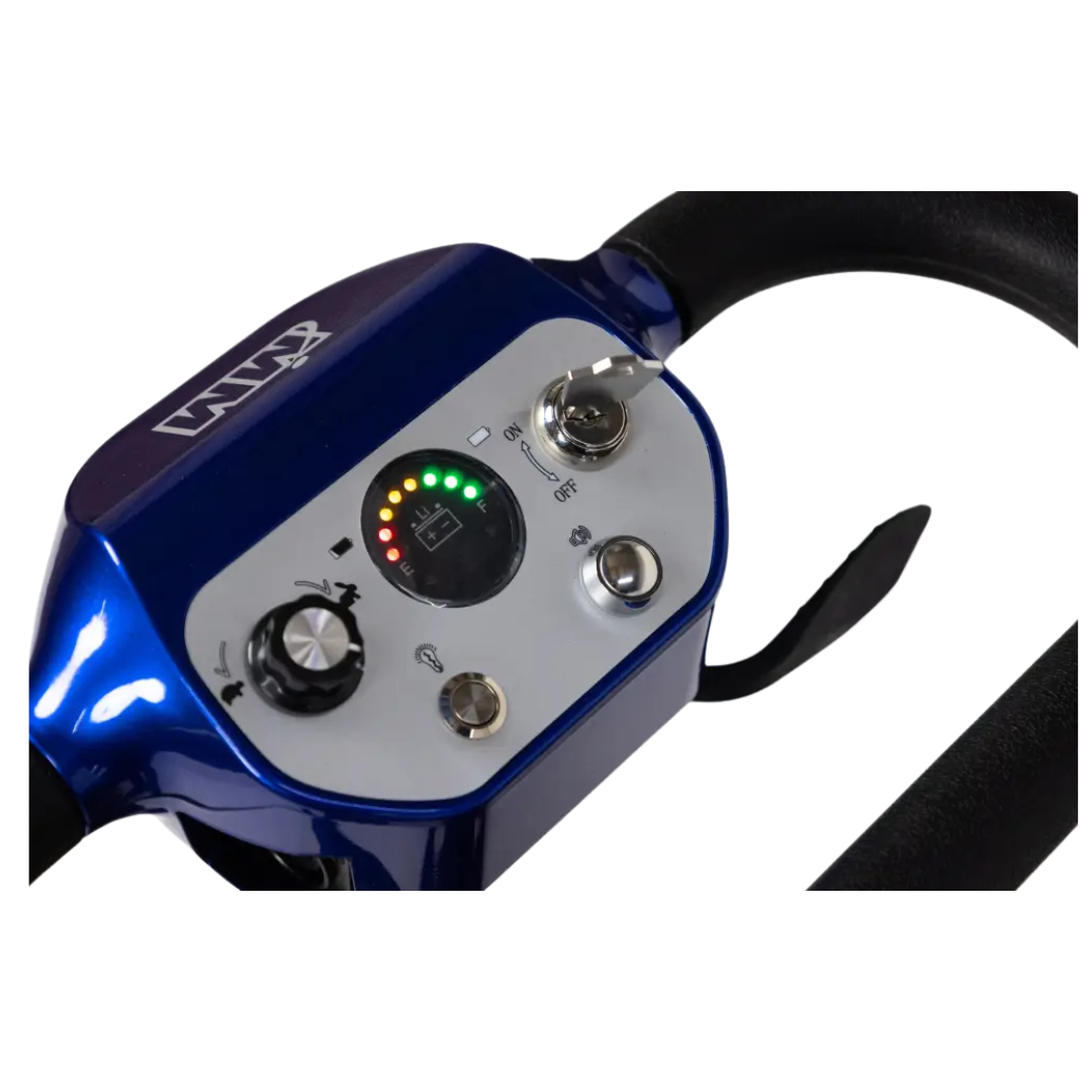 Close-up of the blue and silver control panel on the Monarch Genie Lightweight Portable Scooter, showing a power switch, rotary dial, buttons, and battery indicator lights in green, yellow, and red.