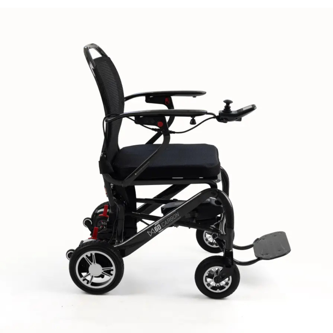 A side view of the Monarch MM60 Carbon Ultralite Electric Wheelchair in black is shown against a plain white background, featuring armrests, a joystick control, and a footrest.