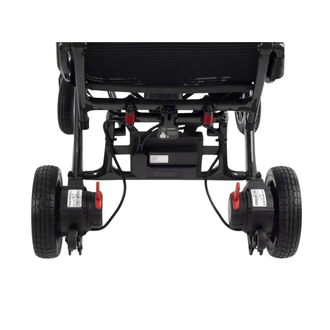 Rear view of the bottom part of a Monarch MM60 Carbon Ultralite Electric Wheelchair in black, displaying large wheels, suspension springs, battery pack, and mechanical components against a white background.