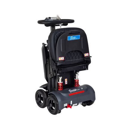 The Monarch Genie Auto Folding Portable Scooter is shown upright and folded for storage or travel. It’s black with four wheels, red suspension springs, and a padded seat featuring the “Genie” logo—ideal for portable, easy mobility.