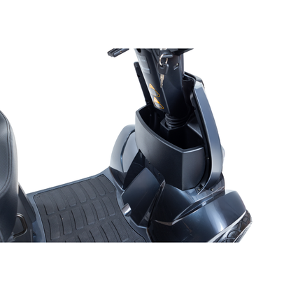 Close-up of the front storage compartment of the Monarch Obsidian HD Outdoor Mobility Scooter, showing the floor mat and seat with the lid open. Refer to specifications and warranty details for more information.