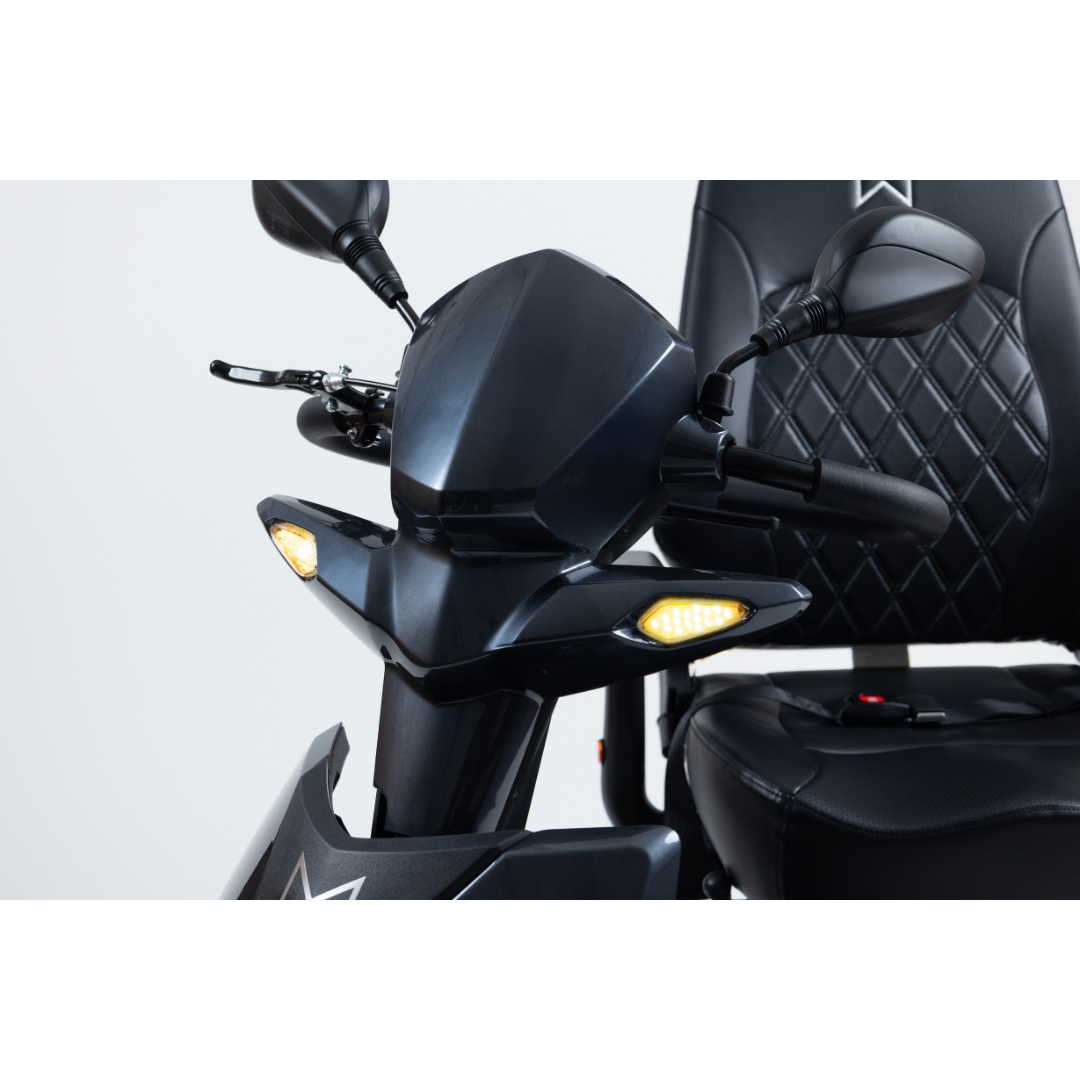 Close-up of the Monarch Obsidian HD Outdoor Mobility Scooter featuring a modern black design, quilted seat, and yellow indicator lights against a white background. See specs for full feature list and warranty details.