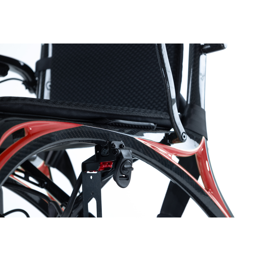 Close-up of the Monarch Ezi Fold Carbon Portable Power Wheelchair, featuring its modern red and black lightweight frame, visible side seat, backrest, and part of the wheel mechanism against a white background.