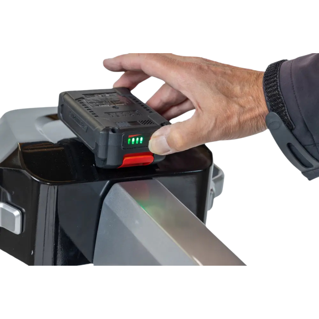 A hand places a rechargeable battery onto the Monarch Atlas 4 Portable Car Lift - Mobility Aid Lifter, with green indicator lights illuminated on the battery.