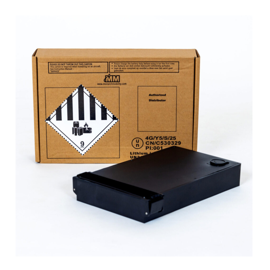 An Extra Batteries For Monarch Mobility Scooters - Lithium Ion pack sits on a white surface in front of a cardboard shipping box with a lithium battery hazard label, ready to use as a spare for your mobility scooter.