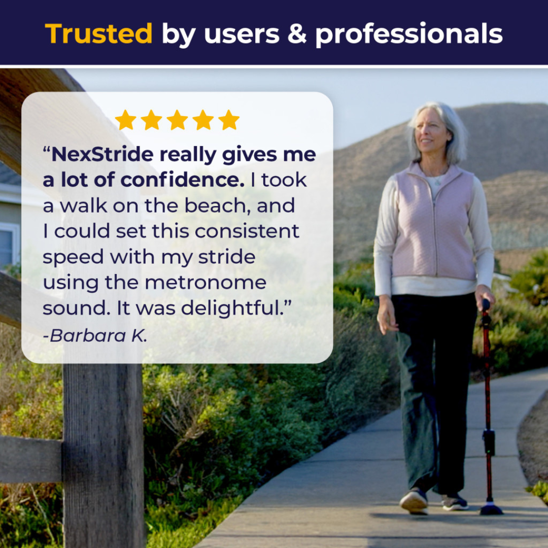 An older woman with gray hair walks outdoors using a walking cane and the NexStride® Visual and Auditory Cueing Device For Walking Aids. In a five-star review, Barbara K. shares that the helpful auditory and visual cues of NexStride® gave her more confidence and enjoyment during a beach walk.