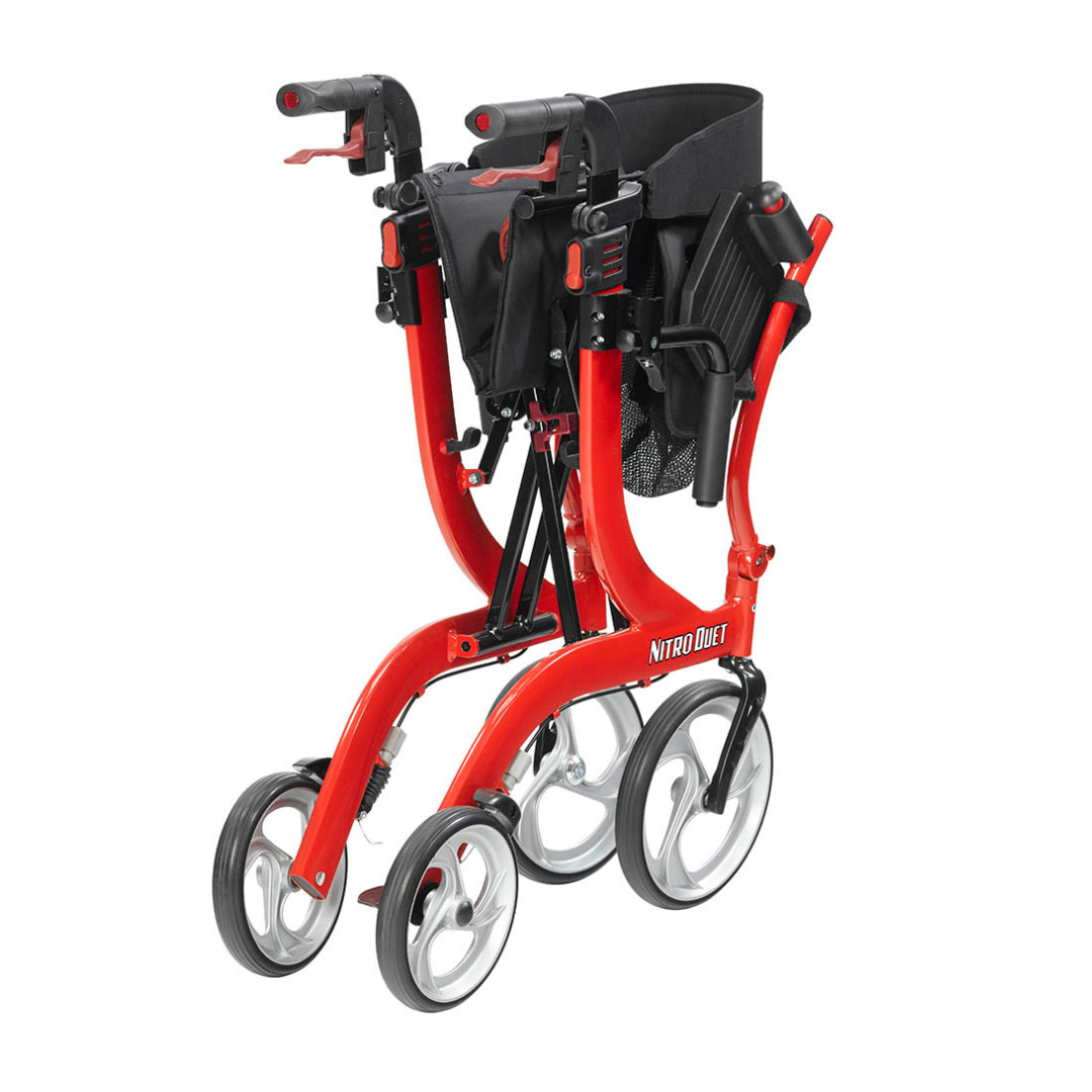 A red Drive Hybrid Nitro® Duet Rollator and Transport Chair is folded for storage, featuring four large wheels, black handles, and a black seat. Its portable design and convenient folding mechanism offer versatile mobility support.